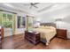 Bright main bedroom featuring hardwood floors, large windows, and a tray ceiling at 201 Aster Ct, Canton, GA 30114