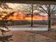 Scenic neighborhood view featuring a vibrant sunset backdrop and mature trees at 201 Aster Ct, Canton, GA 30114