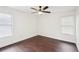 Bright bedroom with dark hardwood floors, ceiling fan, and natural light through two windows at 2201 Huntingdon Chase St, Atlanta, GA 30350