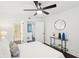 Bright bedroom has dark floors, ensuite bathroom, ceiling fan, and modern console table at 2201 Huntingdon Chase St, Atlanta, GA 30350
