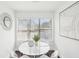 Bright dining area boasts a white table, four chairs, a large window, and modern art at 2201 Huntingdon Chase St, Atlanta, GA 30350