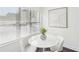 Bright dining area features white table, four chairs, large window, and abstract wall art at 2201 Huntingdon Chase St, Atlanta, GA 30350