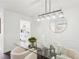 Elegant dining room with modern light fixture, glass table, and seating for four at 2201 Huntingdon Chase St, Atlanta, GA 30350