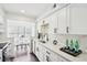 Bright kitchen features white cabinets, marble backsplash, and adjacent breakfast nook with a view at 2201 Huntingdon Chase St, Atlanta, GA 30350