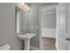 Bright bathroom featuring a pedestal sink, large mirror, and modern fixtures at 1179 Bennett Creek Overlook, Suwanee, GA 30024