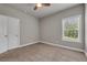 Bedroom with carpet, ceiling fan, neutral paint and view of outside through window at 1179 Bennett Creek Overlook, Suwanee, GA 30024