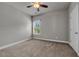 This carpeted bedroom has a ceiling fan, neutral walls, and a window at 1179 Bennett Creek Overlook, Suwanee, GA 30024