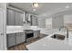 Kitchen features gray cabinets, stainless steel appliances, a spacious countertop and a view of the dining area at 1179 Bennett Creek Overlook, Suwanee, GA 30024