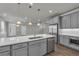 Spacious kitchen with stainless steel appliances, hardwood floors, granite countertops, gray cabinetry and open floor plan at 1179 Bennett Creek Overlook, Suwanee, GA 30024