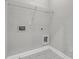 Functional laundry area with tile floors and wall-mounted shelf at 1179 Bennett Creek Overlook, Suwanee, GA 30024