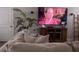 Comfortable living area features an off-white sofa, modern media center, large television, and neutral decor at 1179 Bennett Creek Overlook, Suwanee, GA 30024