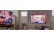Cozy living room with neutral sofa, throw pillows, two large-screen televisions, and ambient lighting at 1179 Bennett Creek Overlook, Suwanee, GA 30024