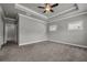 Spacious main bedroom featuring carpet, tray ceiling, and open doorway at 1179 Bennett Creek Overlook, Suwanee, GA 30024