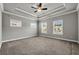Spacious main bedroom featuring carpet, tray ceiling, and multiple windows at 1179 Bennett Creek Overlook, Suwanee, GA 30024