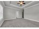 Spacious carpeted bedroom with tray ceilings and multiple doorways at 1179 Bennett Creek Overlook, Suwanee, GA 30024