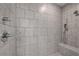Walk-in shower with gray stone tile surround and mounted shower head at 1179 Bennett Creek Overlook, Suwanee, GA 30024