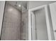 Walk-in shower with glass partition and stone tile surround at 1179 Bennett Creek Overlook, Suwanee, GA 30024