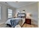 Comfortable bedroom featuring hardwood floors, nightstands, decorative pillows, and modern abstract art at 3364 Old Concord Se Rd, Smyrna, GA 30082