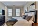 Well-lit bedroom with two large windows, stylish bedding, and a dark wood dresser at 3364 Old Concord Se Rd, Smyrna, GA 30082
