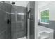 Bathroom featuring gray tile shower, soaking tub, and modern fixtures near a window at 3487 Creekview Dr, Rex, GA 30273