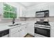 Bright kitchen featuring white cabinets, stainless steel appliances, gray backsplash, and a window at 3487 Creekview Dr, Rex, GA 30273