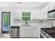 Modern kitchen with white cabinetry, new appliances, and wood-style flooring, near walkout deck at 3487 Creekview Dr, Rex, GA 30273