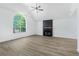 Bright living room featuring vaulted ceiling, arched window, fireplace, and wood flooring at 3487 Creekview Dr, Rex, GA 30273