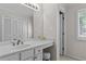 Bright bathroom with a vanity, a window and an adjacent closet with louvered doors at 403 S River Farm Dr, Alpharetta, GA 30022