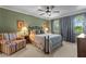 Cozy bedroom with a wrought iron bed, side chair and large window with natural light at 403 S River Farm Dr, Alpharetta, GA 30022