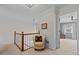 Upstairs hallway with decorative chair and view into room, neutral walls and white trim at 403 S River Farm Dr, Alpharetta, GA 30022