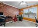 Bedroom with a brick accent wall, natural light, and ceiling fan at 704 Williamsburg Ct, Villa Rica, GA 30180