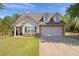 Charming home featuring a two-car garage, stone accents, dormer windows, and a well-manicured lawn at 704 Williamsburg Ct, Villa Rica, GA 30180