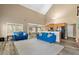 Open-concept living area with modern furniture, high ceilings, and a view of the kitchen at 704 Williamsburg Ct, Villa Rica, GA 30180
