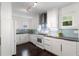 Modern white kitchen featuring sleek cabinets, stainless steel appliances, and stylish blue tiled backsplash at 830 Belgrade Ne Ave, Atlanta, GA 30306