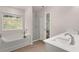 Bright bathroom featuring a soaking tub, shower, and double sinks by a window view at 1344 Riverstone Rd # 108, Jonesboro, GA 30238