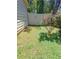 Side yard view with a white gate, rose bushes, green grass and fence at 2044 Mallard Crest, Lithonia, GA 30058