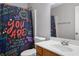 Colorful bathroom featuring a single sink vanity and a shower with a fun shower curtain at 395 Anvil Way, Austell, GA 30168
