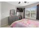 Bedroom showcasing a dresser with mirror, mounted TV, and window with wooded view at 395 Anvil Way, Austell, GA 30168