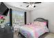 Bright bedroom features large windows, ceiling fan, TV, and cheerful decor at 395 Anvil Way, Austell, GA 30168