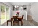 Dining room with a chandelier, slider to the backyard, and views of the living room and staircase at 395 Anvil Way, Austell, GA 30168