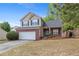 Inviting two-story home showcasing a brick and siding exterior, attached garage, and landscaped front yard under a blue sky at 395 Anvil Way, Austell, GA 30168