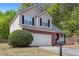 Two-story home with brick and vinyl siding, featuring a two-car garage and a neatly maintained lawn at 395 Anvil Way, Austell, GA 30168