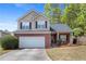 Charming two-story home featuring a brick facade, vinyl siding, and a well-maintained front yard with mature trees at 395 Anvil Way, Austell, GA 30168