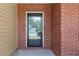 Close-up of a front door with glass insert, framed by brick and siding, offering a glimpse into the interior at 395 Anvil Way, Austell, GA 30168