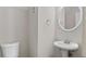 Powder room featuring a pedestal sink, modern fixtures, and a white toilet at 395 Anvil Way, Austell, GA 30168