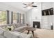 Bright living room with a sectional sofa, a modern fireplace, and a large window, offering a comfortable and stylish space at 395 Anvil Way, Austell, GA 30168