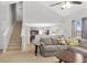 Open-concept living room featuring a vaulted ceiling, staircase, and neutral decor with views into the kitchen at 395 Anvil Way, Austell, GA 30168