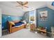 Blue-themed bedroom under eaves featuring a trundle bed, toy storage, and natural light from a single window at 4016 Upland Trce, Marietta, GA 30066