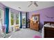 Bright bedroom features large windows, purple walls, a ceiling fan, and a wooden dresser at 4016 Upland Trce, Marietta, GA 30066