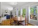 Bright dining area with hardwood floors, large windows offering backyard views, and adjacent fireplace at 4016 Upland Trce, Marietta, GA 30066